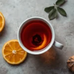 Tè Earl Grey in foglia versato in una tazza chiara con una scorza di bergamotto accanto, vista dall'alto